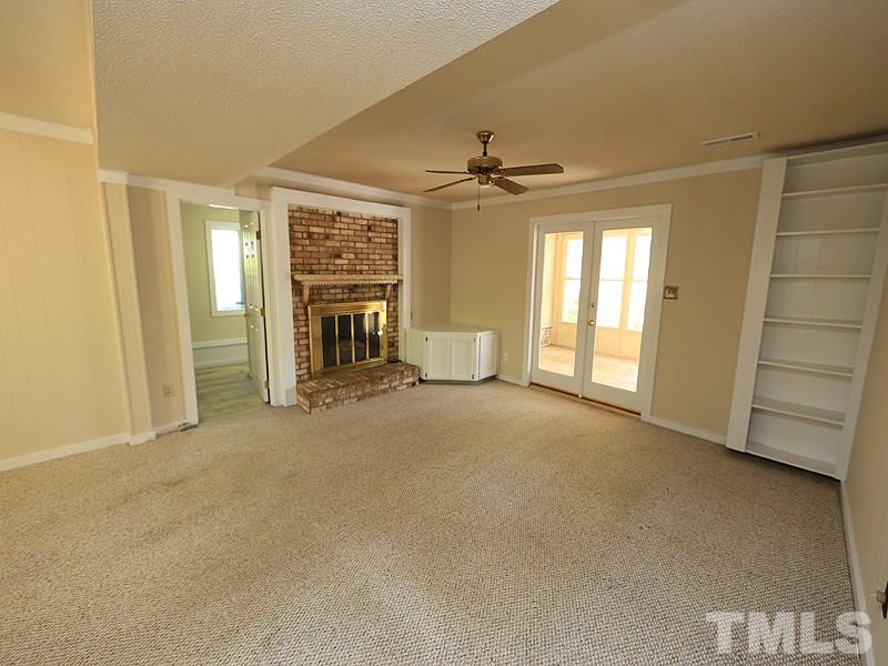 1504 Stratlen Court Raleigh, NC 27615 - Photo 6 of 17 a view of an empty room with a fireplace and a window