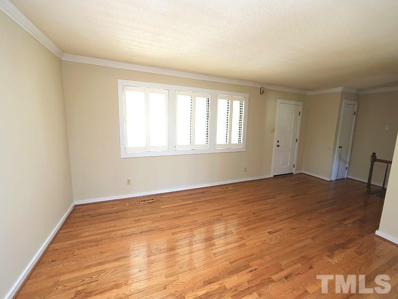 1504 Stratlen Court Raleigh, NC 27615 - Photo 7 of 17 a view of an empty room with wooden floor and a window