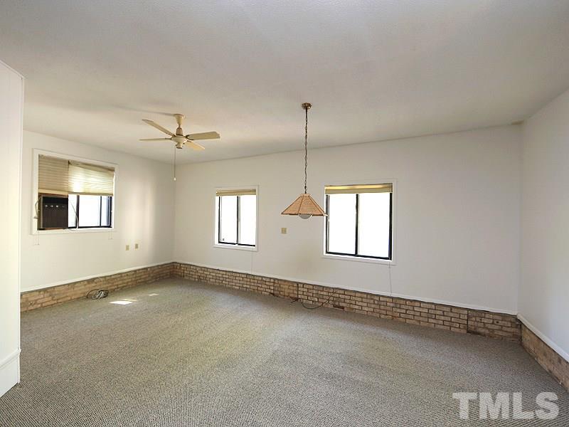 1504 Stratlen Court Raleigh, NC 27615 - Photo 10 of 17 an empty room with windows and ceiling fan
