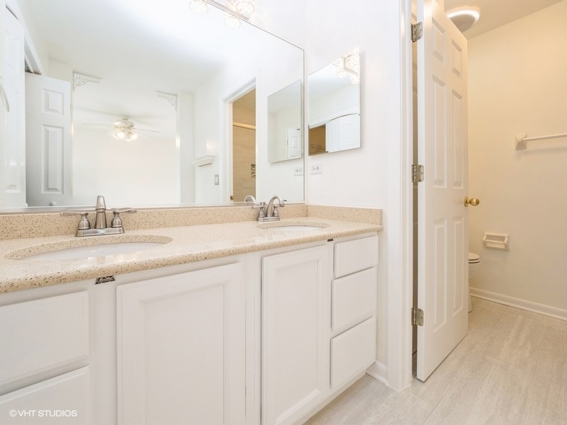140 Crescent Lane Schaumburg, IL 60193 - Photo 11 of 21 a bathroom with a double vanity sink and a mirror