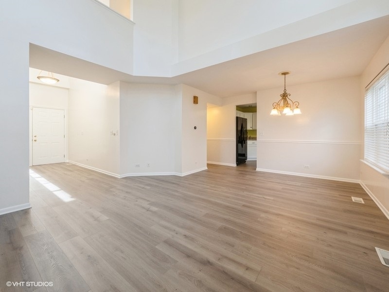 140 Crescent Lane Schaumburg, IL 60193 - Photo 4 of 21 an empty room with wooden floor and windows