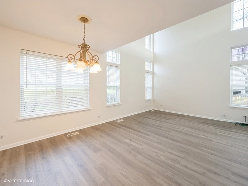 140 Crescent Lane Schaumburg, IL 60193 - Photo 5 of 21 a view of an empty room with wooden floor and a window