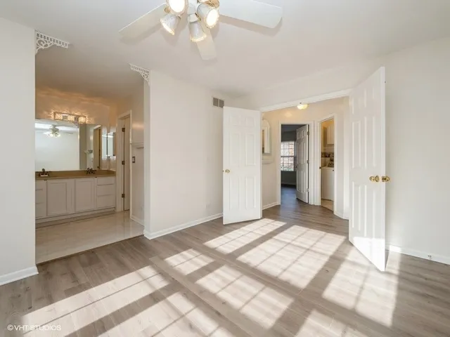 a view of a big room with wooden floor and a kitchen