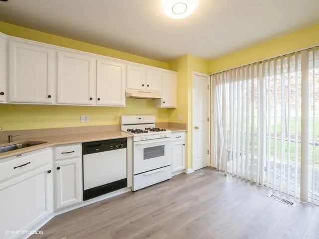 a kitchen with granite countertop white cabinets and white appliances