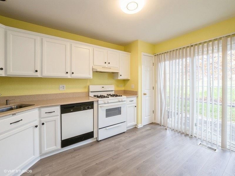 140 Crescent Lane Schaumburg, IL 60193 - Photo 8 of 21 a kitchen with granite countertop white cabinets and white appliances