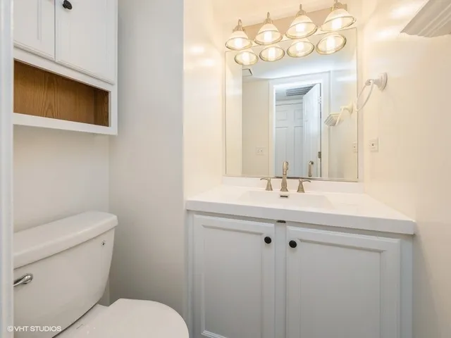 a bathroom with a toilet a sink and mirror