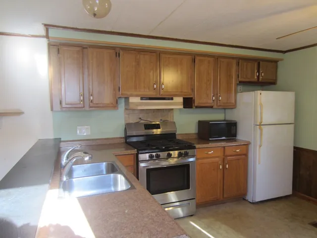 a kitchen with a refrigerator a stove a sink and a cabinets