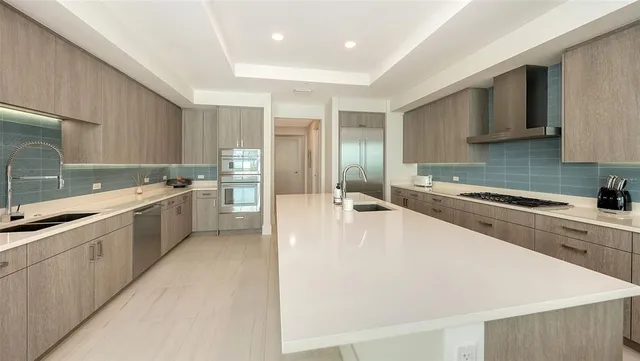 a bedroom with a large bed and a chandelier