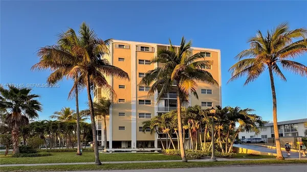 a view of a tall building with a palm trees