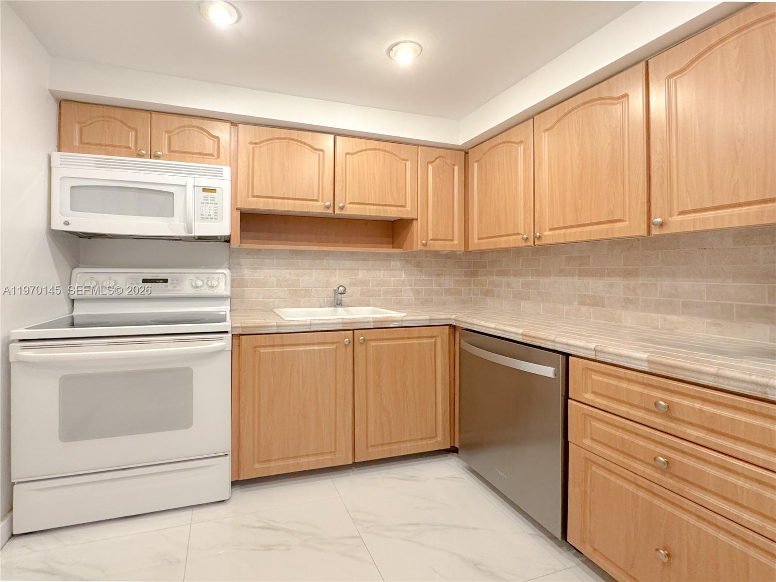 555 Crandon Boulevard, Unit 82 Key Biscayne, FL 33149 - Photo 11 of 28 a kitchen with cabinets appliances a sink and a window