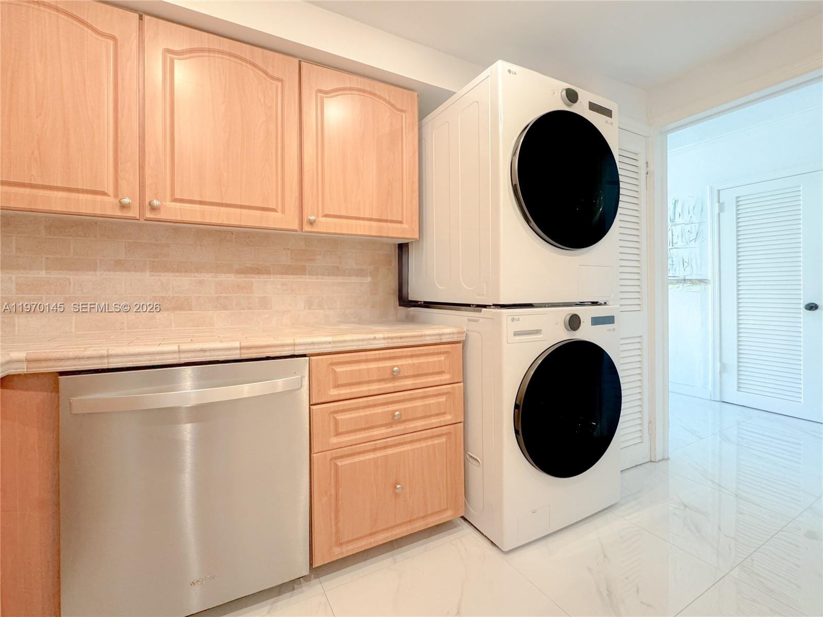555 Crandon Boulevard, Unit 82 Key Biscayne, FL 33149 - Photo 12 of 28 a kitchen with a washer and dryer