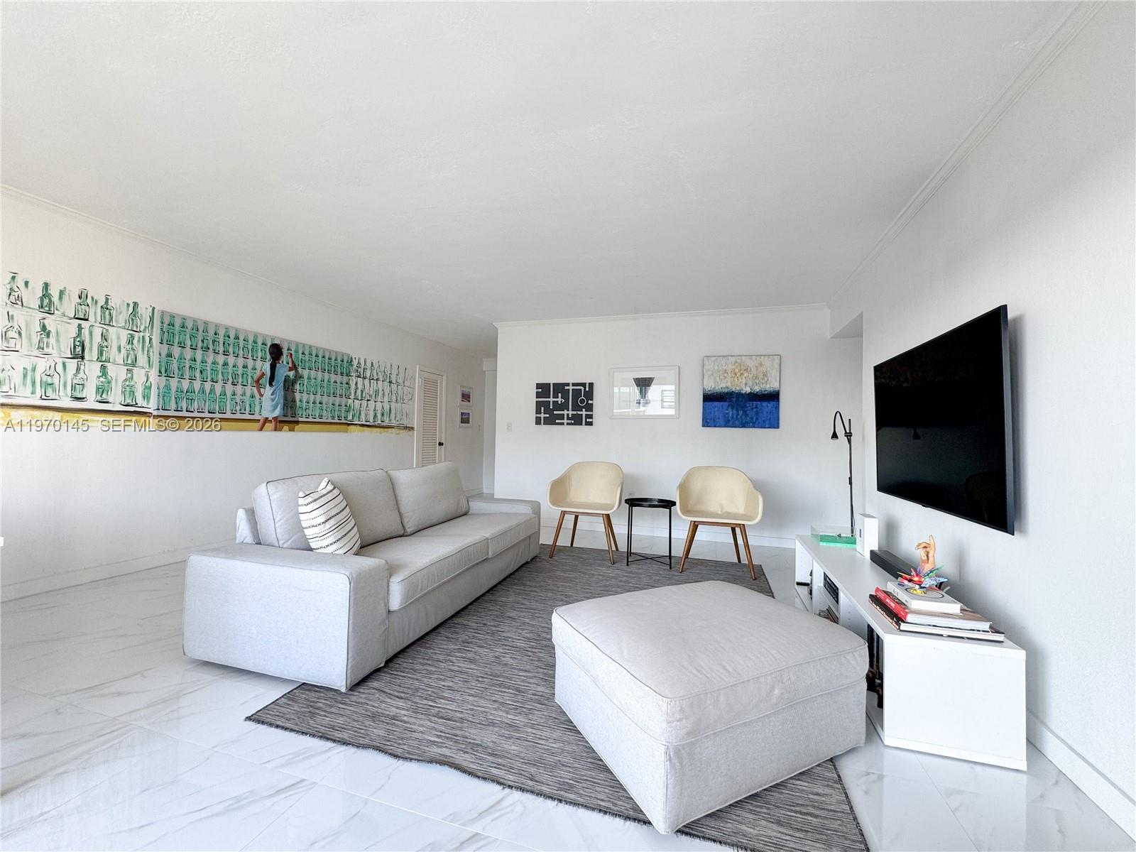 555 Crandon Boulevard, Unit 82 Key Biscayne, FL 33149 - Photo 3 of 28 a living room with furniture and a flat screen tv