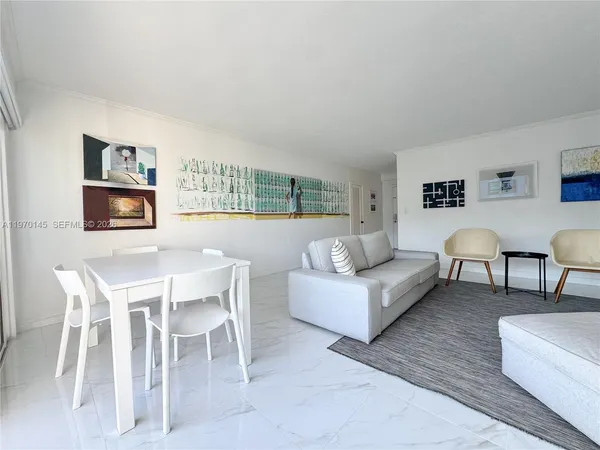 a living room with furniture and a painting on the wall