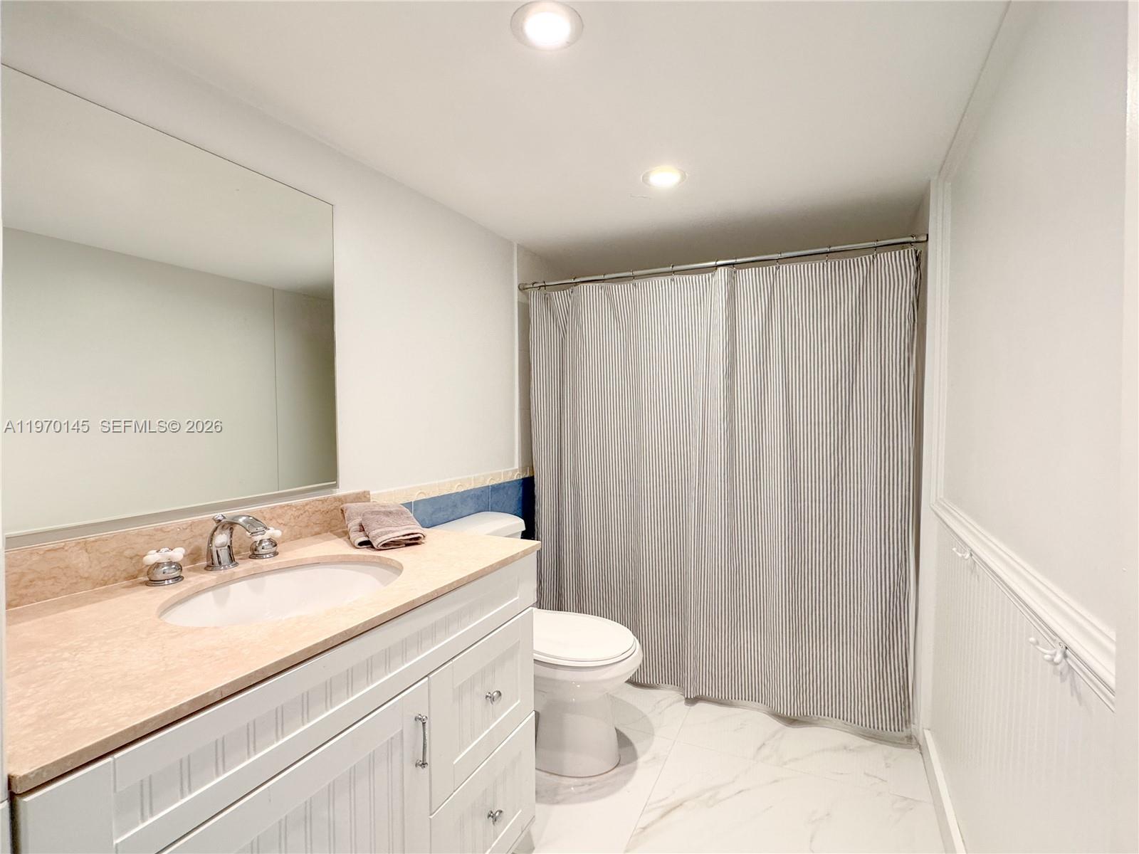 555 Crandon Boulevard, Unit 82 Key Biscayne, FL 33149 - Photo 8 of 28 a bathroom with a sink a toilet and shower