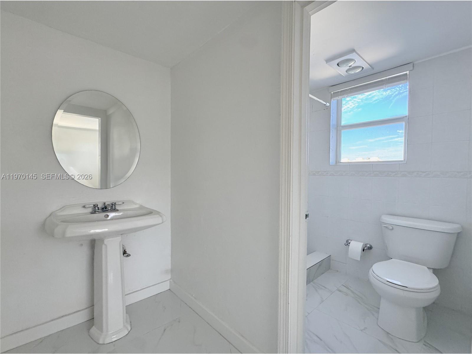 555 Crandon Boulevard, Unit 82 Key Biscayne, FL 33149 - Photo 9 of 28 a bathroom with a toilet a sink and mirror