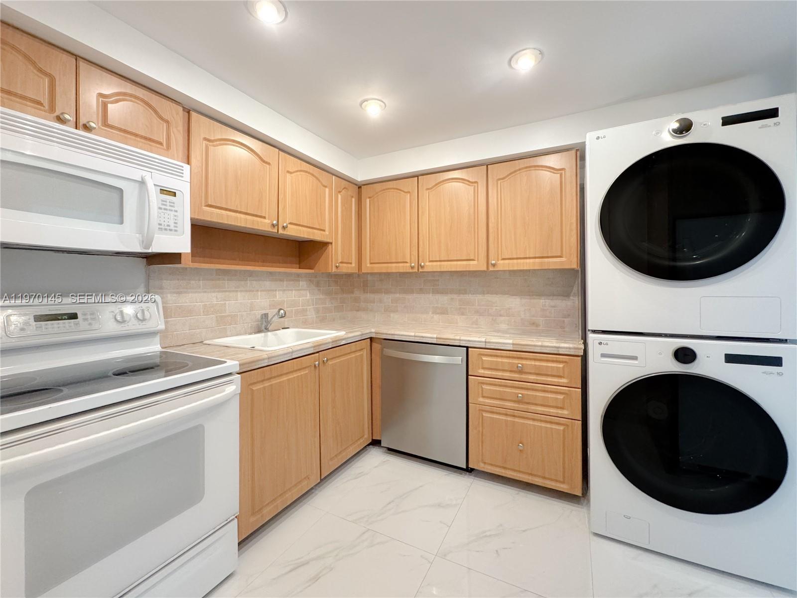 555 Crandon Boulevard, Unit 82 Key Biscayne, FL 33149 - Photo 10 of 28 a kitchen with a washer and dryer