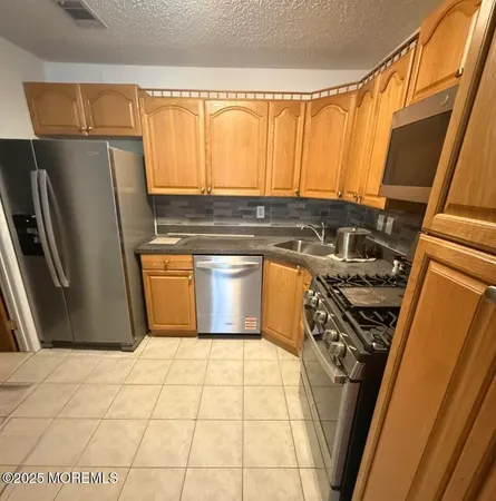 a kitchen with a refrigerator a stove top oven and cabinets