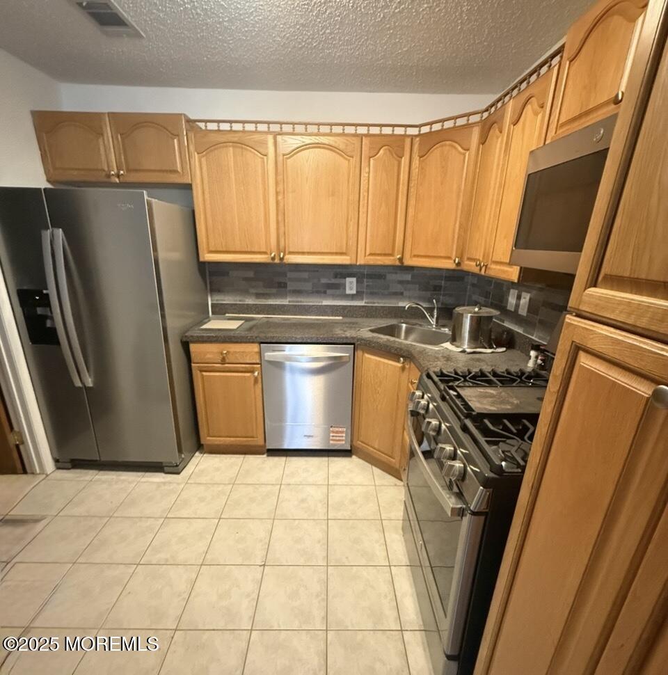 17-7 Augusta Court Freehold, NJ 07728 - Photo 1 of 6 a kitchen with a refrigerator a stove top oven and cabinets