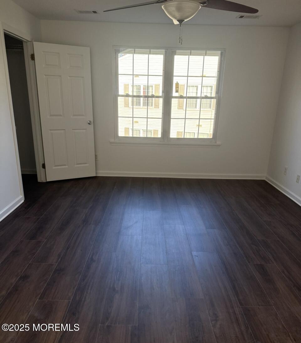 17-7 Augusta Court Freehold, NJ 07728 - Photo 4 of 6 an empty room with wooden floor and windows