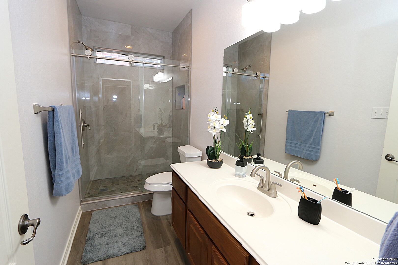 8614 Mantano Ridge Helotes, TX 78023 - Photo 26 of 36 a bathroom with a double vanity sink toilet and shower
