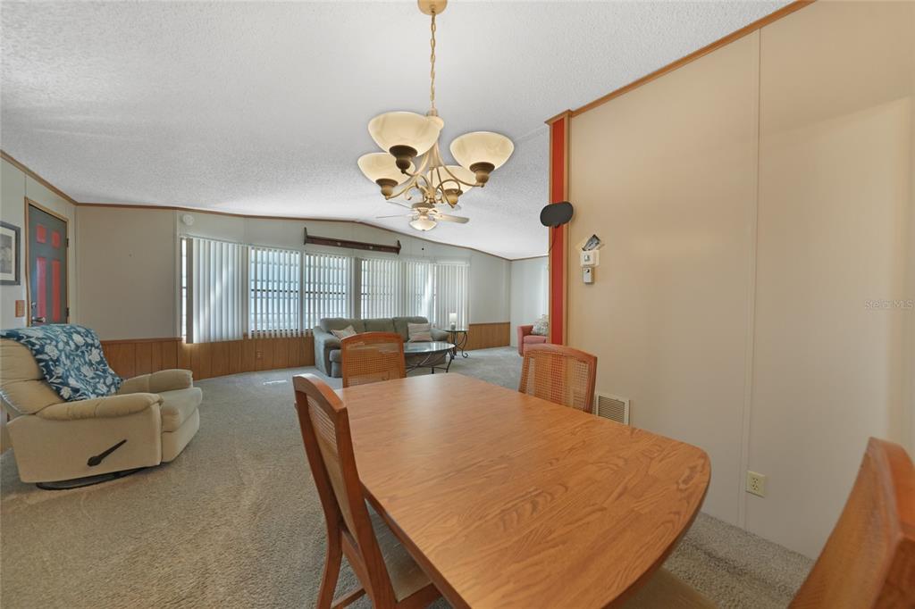 10101 Burnt Store Road, Unit 54 Punta Gorda, FL 33950 - Photo 11 of 28 a view of a dining room with furniture and a chandelier