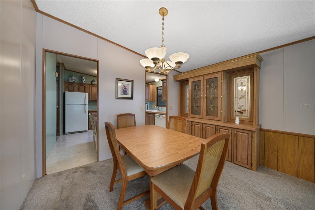 10101 Burnt Store Road, Unit 54 Punta Gorda, FL 33950 - Photo 12 of 28 a view of a dining room with furniture and a chandelier