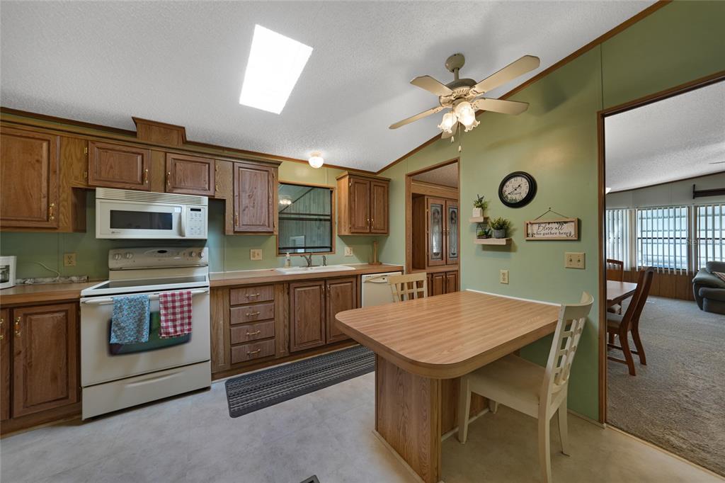 10101 Burnt Store Road, Unit 54 Punta Gorda, FL 33950 - Photo 13 of 28 a kitchen with a table chairs microwave and cabinets