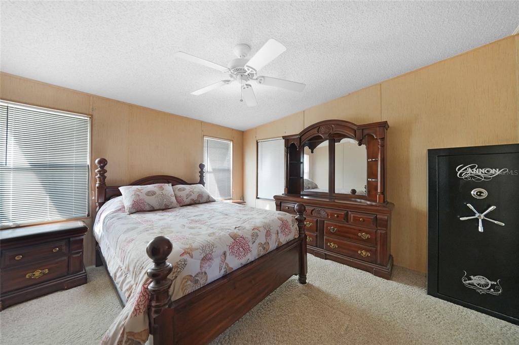 10101 Burnt Store Road, Unit 54 Punta Gorda, FL 33950 - Photo 16 of 28 a bedroom with a bed and a dresser with mirror