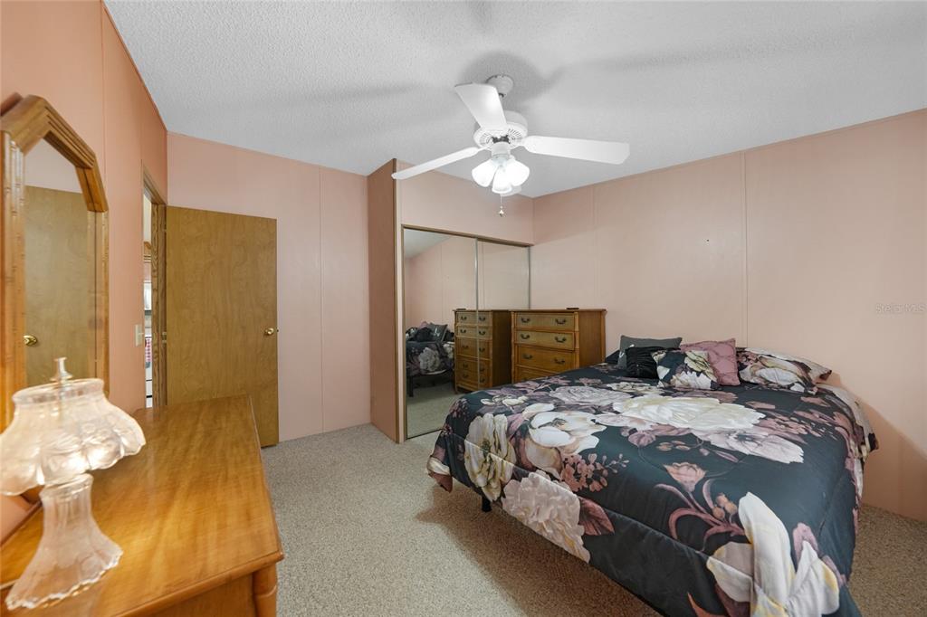 10101 Burnt Store Road, Unit 54 Punta Gorda, FL 33950 - Photo 21 of 28 a bedroom with a bed and chandelier