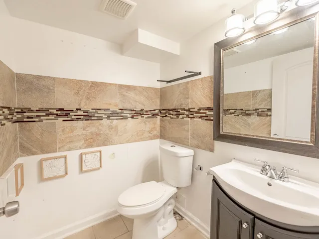 a bathroom with a toilet sink and mirror