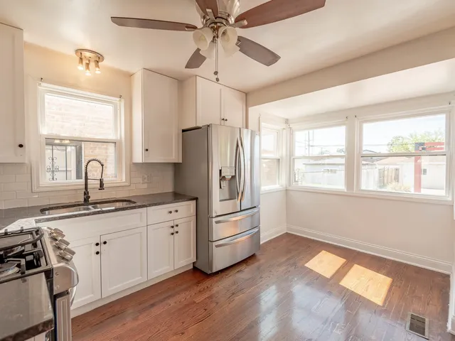 a kitchen with granite countertop a sink appliances cabinets and a large window