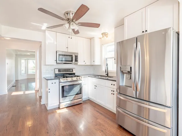a kitchen with cabinets stainless steel appliances and a refrigerator