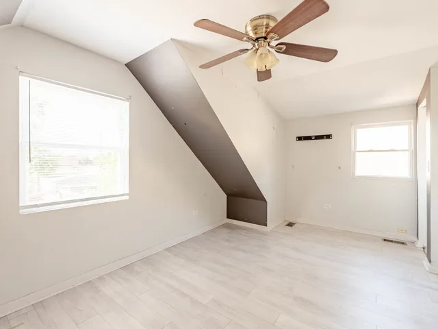 an empty room with a window and a fan