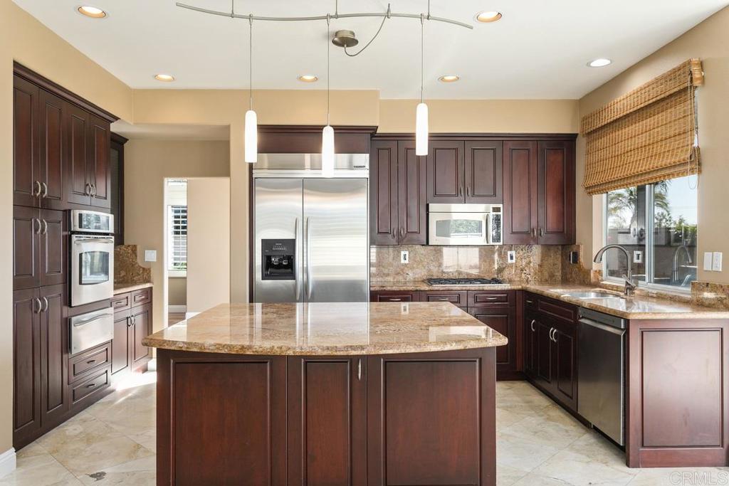 6947 Dusty Rose Place Carlsbad, CA 92011 - Photo 15 of 50 a kitchen with stainless steel appliances granite countertop a sink a stove and refrigerator