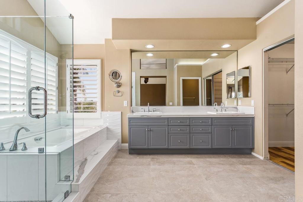 6947 Dusty Rose Place Carlsbad, CA 92011 - Photo 27 of 50 a large bathroom with a large tub sink vanity and granite