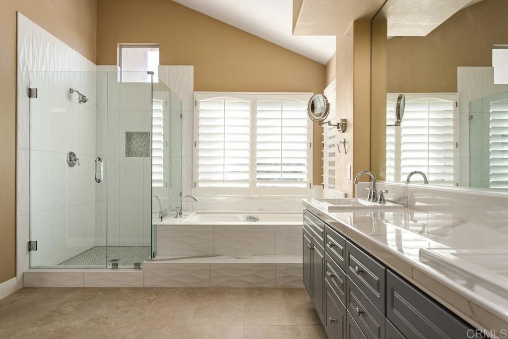 6947 Dusty Rose Place Carlsbad, CA 92011 - Photo 28 of 50 a spacious bathroom with a granite countertop tub sink and next to a window