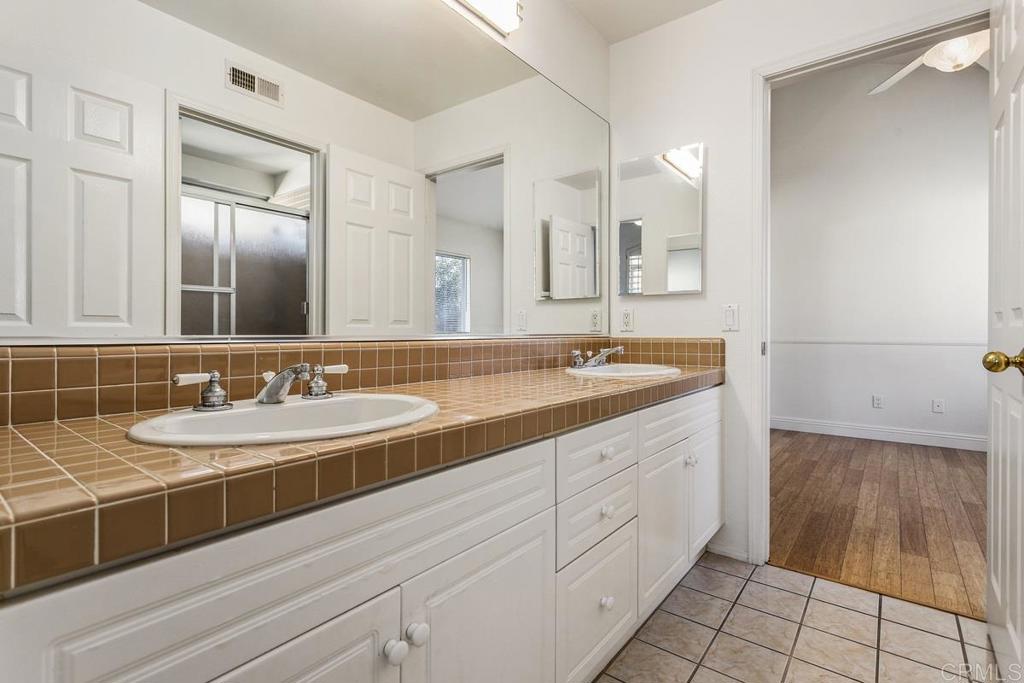 6947 Dusty Rose Place Carlsbad, CA 92011 - Photo 34 of 50 a bathroom with a double vanity sink a mirror and a