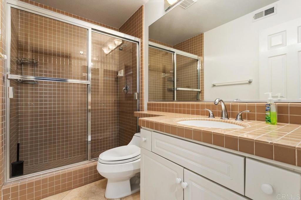 6947 Dusty Rose Place Carlsbad, CA 92011 - Photo 36 of 50 a bathroom with a sink a toilet and shower
