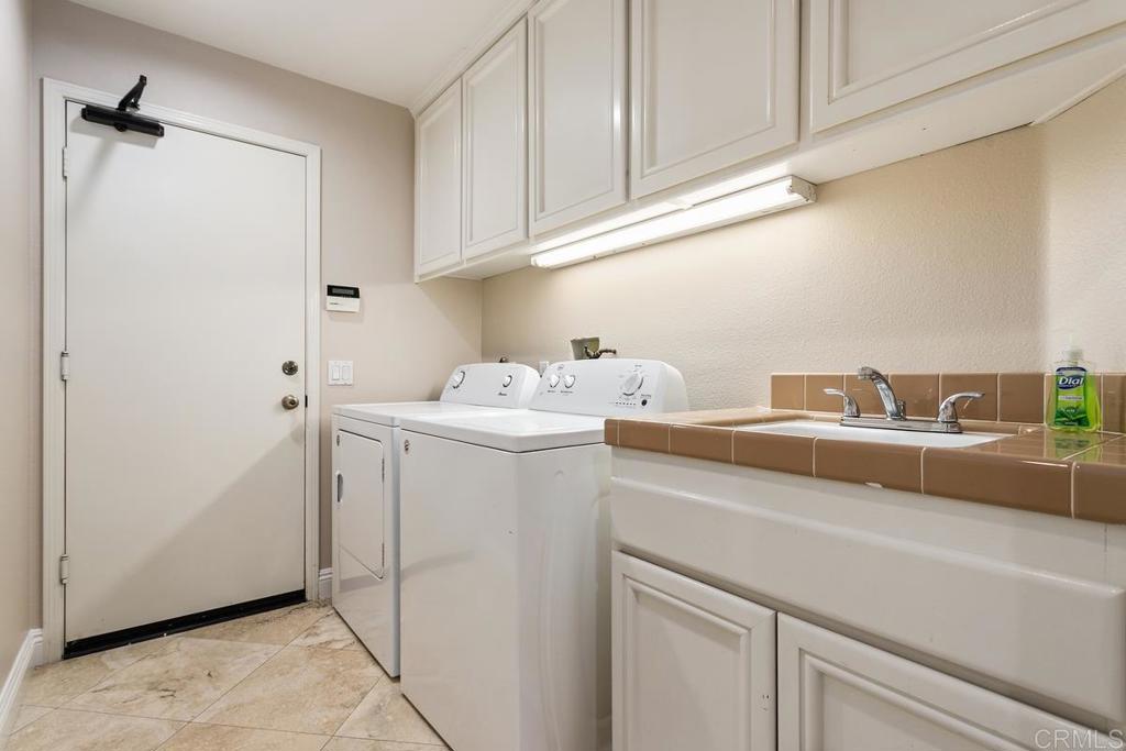 6947 Dusty Rose Place Carlsbad, CA 92011 - Photo 38 of 50 a utility room with cabinets washer and dryer