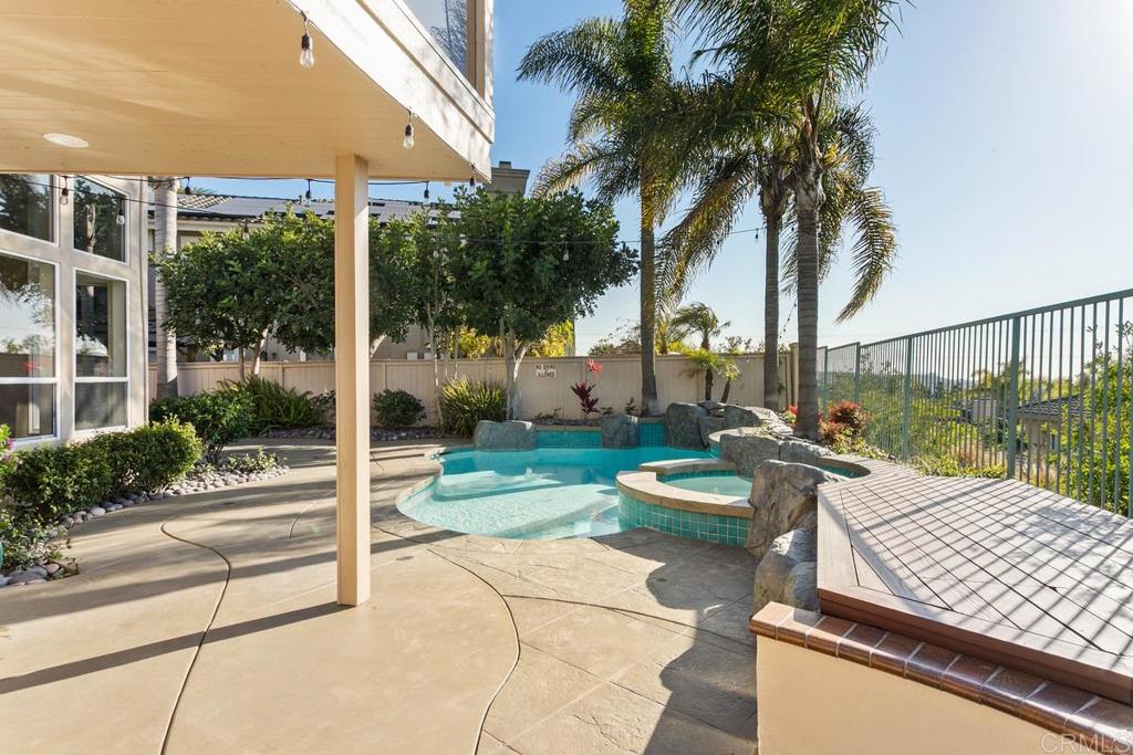 6947 Dusty Rose Place Carlsbad, CA 92011 - Photo 41 of 50 a view of a patio with table and chairs potted plants and palm tree