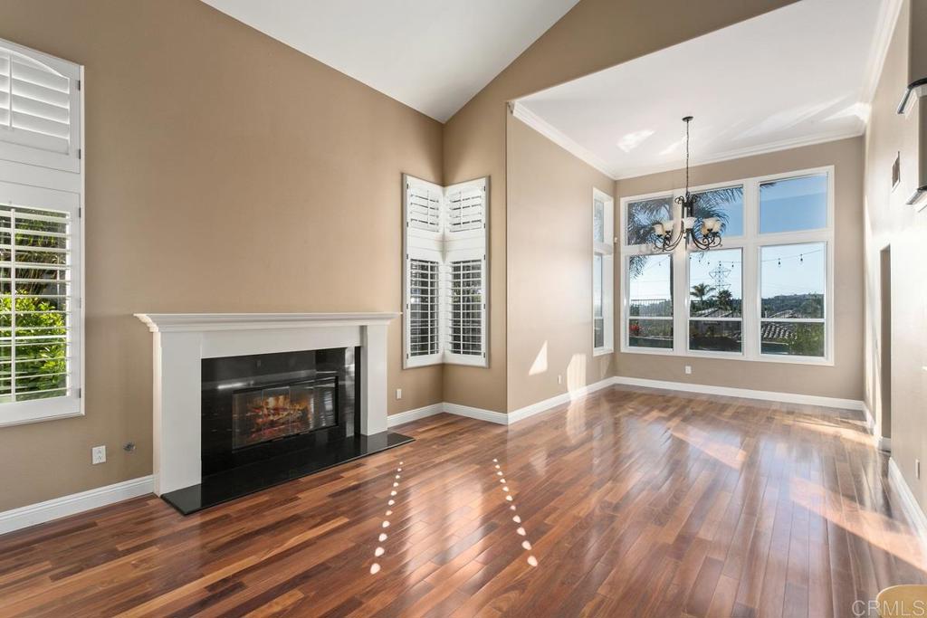 6947 Dusty Rose Place Carlsbad, CA 92011 - Photo 9 of 50 a view of an empty room with wooden floor fireplace and a window