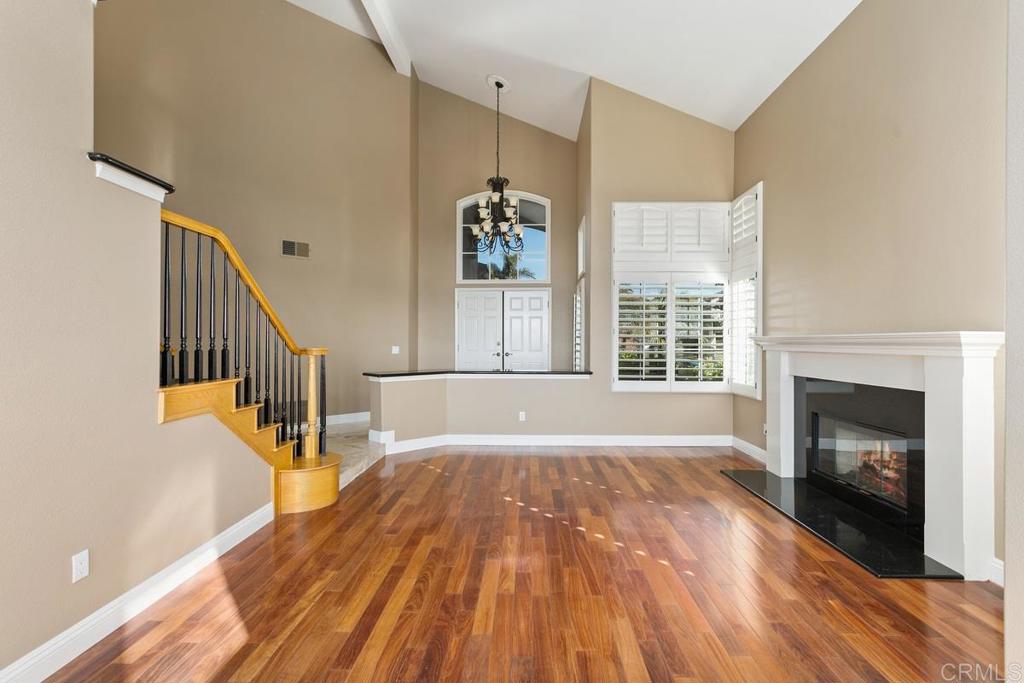 6947 Dusty Rose Place Carlsbad, CA 92011 - Photo 10 of 50 a view of an empty room with wooden floor fireplace and a window