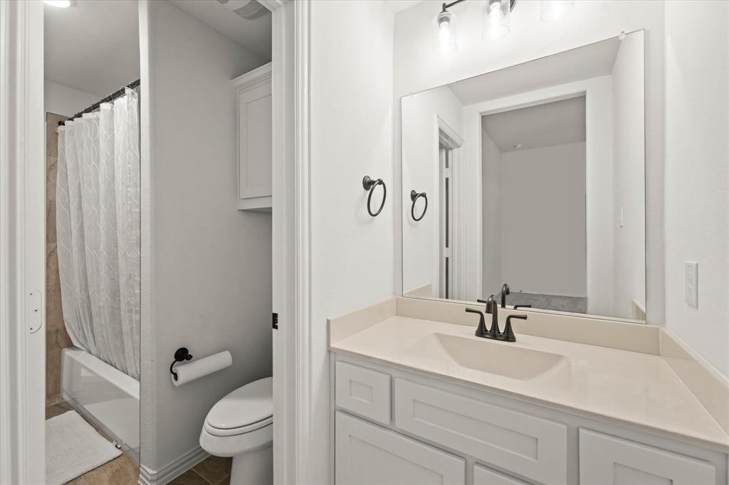 1111 Alaska Drive Forney, TX 75126 - Photo 11 of 30 a bathroom with a sink a toilet and a mirror