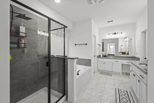 a large bathroom with a glass shower door and a mirror