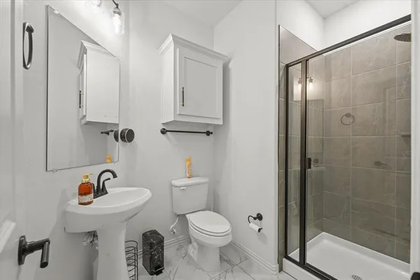 a bathroom with a sink a toilet and shower