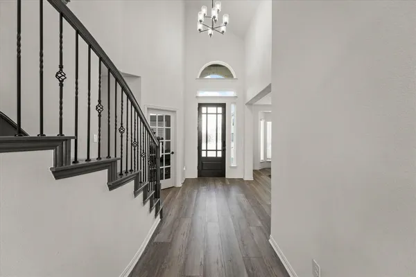 a view of a hallway with wooden floor and staircase