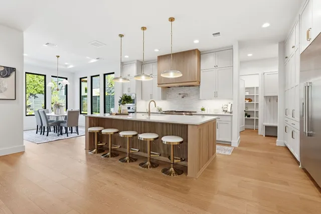 a large kitchen with kitchen island a large center island and stainless steel appliances