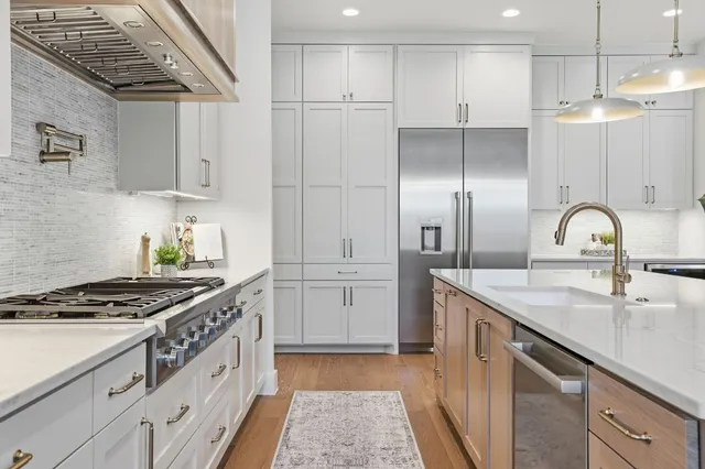 a kitchen with white cabinets and appliances