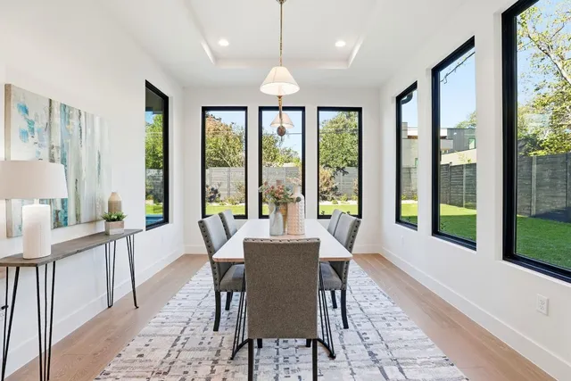 a view of a dining room with furniture large windows and wooden floor