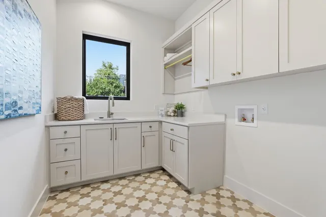 a room with white cabinets and sink